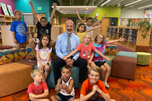  Superintendent Gothard with students in a colorful library