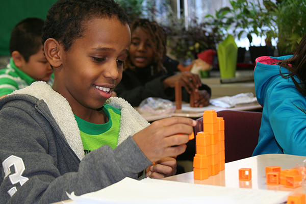  Young boy stacking orange unifix cubes