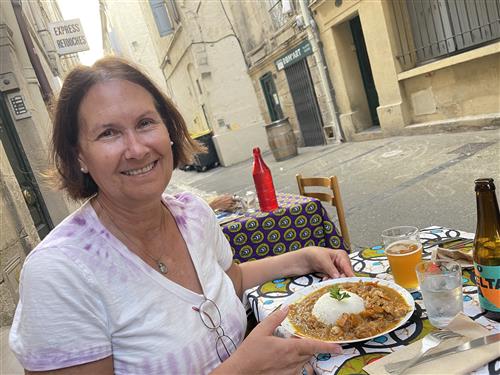 Ms. Teefy enjoys the west African dish of “poulet yassa” (spicy chicken and rice) at an outdoor Malian restaurant in Montpell