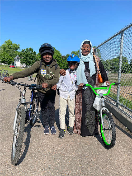 Two students and a parent biking to school