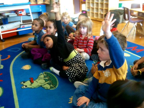 Children raising hand in class