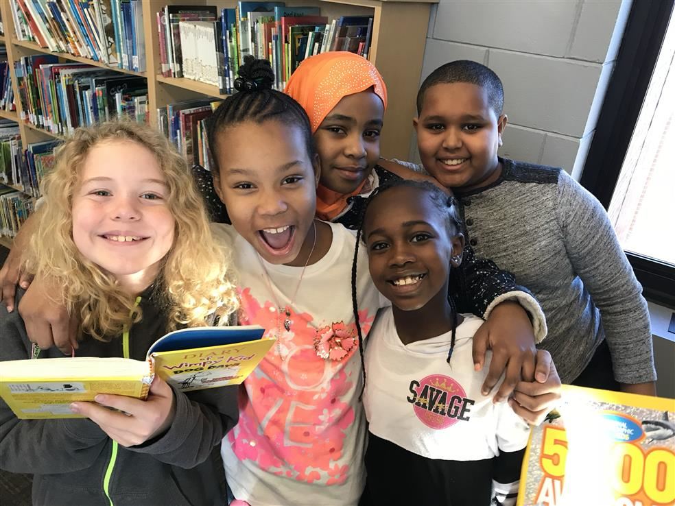 A group of smiling children in a library.