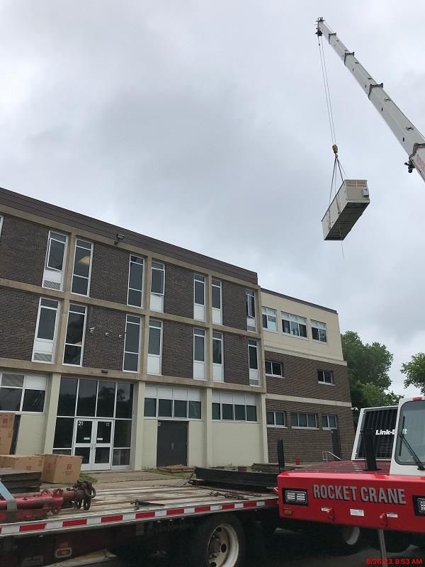 New rooftop mechanical unit being lifted into place